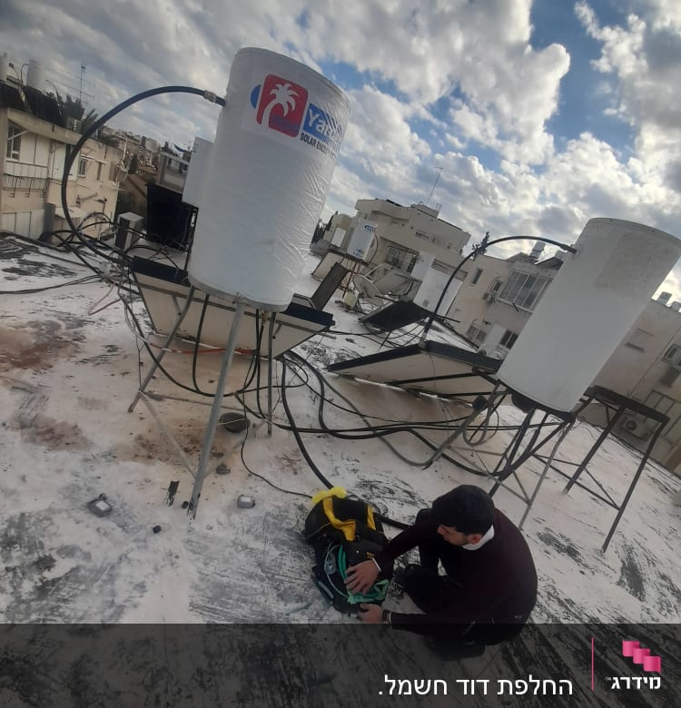 דוד שמש על גג עם אדם מתקן צנרת